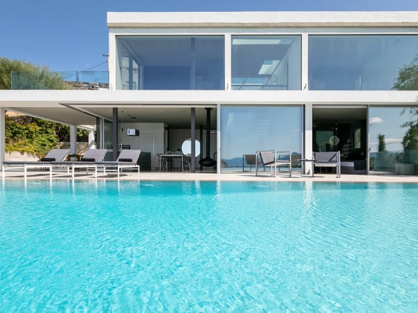 The glass façade of Aeacus seen from beside the pool.